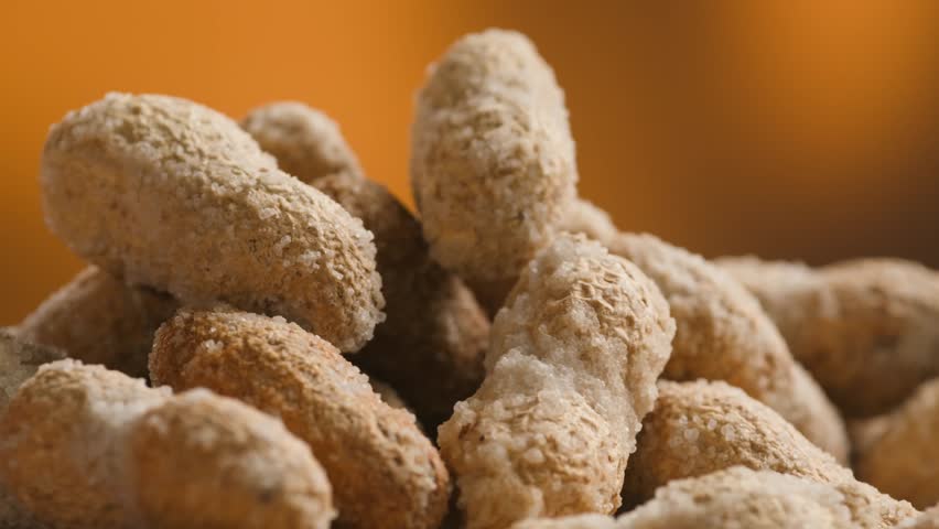 Peanuts in Salted Shell Man Cracking and Eating Salty Nuts as a Classic Bar Snack at Cafe