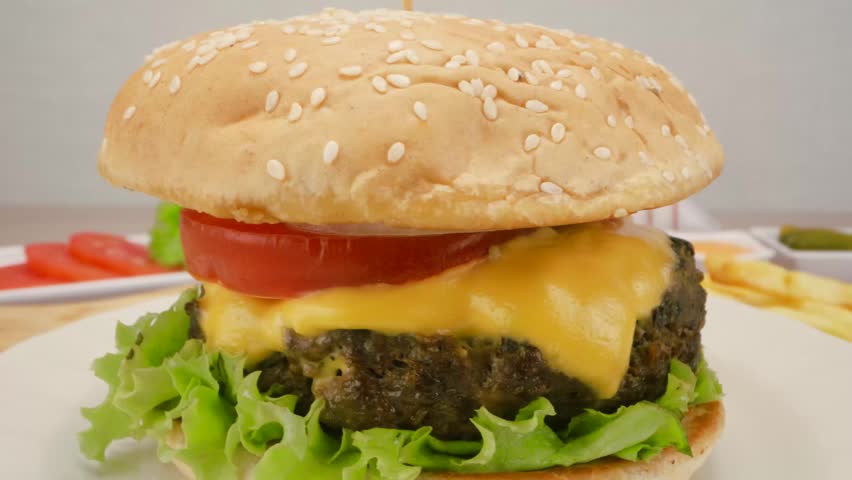 Juicy classic beef burger with melted cheddar cheese lettuce and tomato slices.