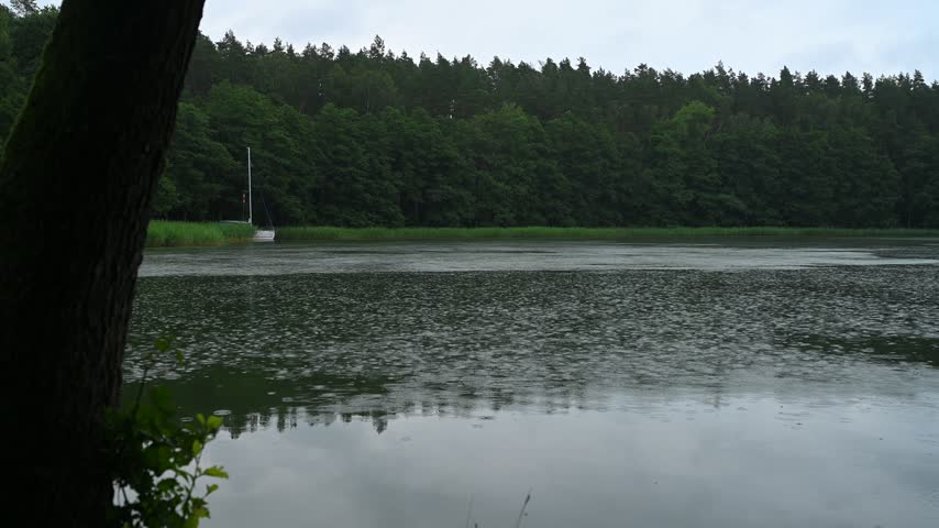 Poland, Masurian Lakes, lake water surface, rain falling, water droplets, twilight