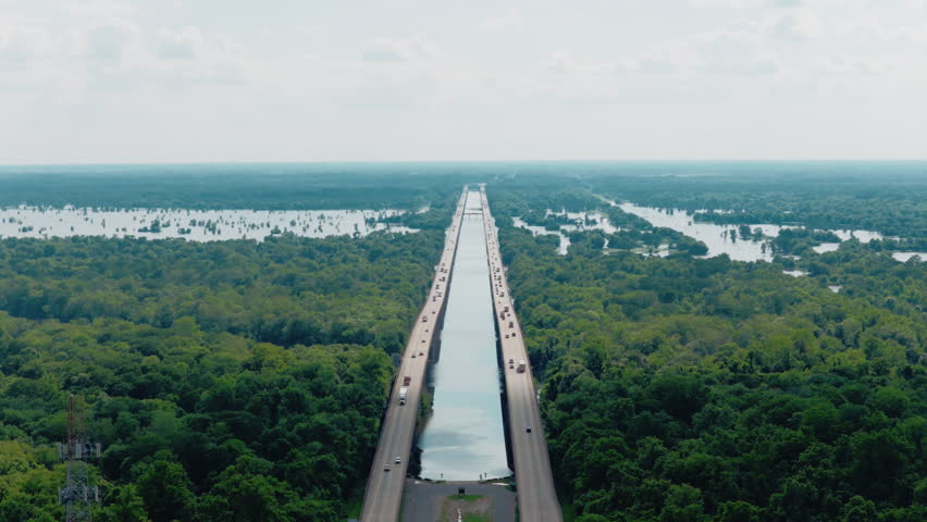 Drone flight over the Atchafalaya Basin Bridge on Interstate 10, showing the long twin spans stretching across the Louisiana swamp and river.