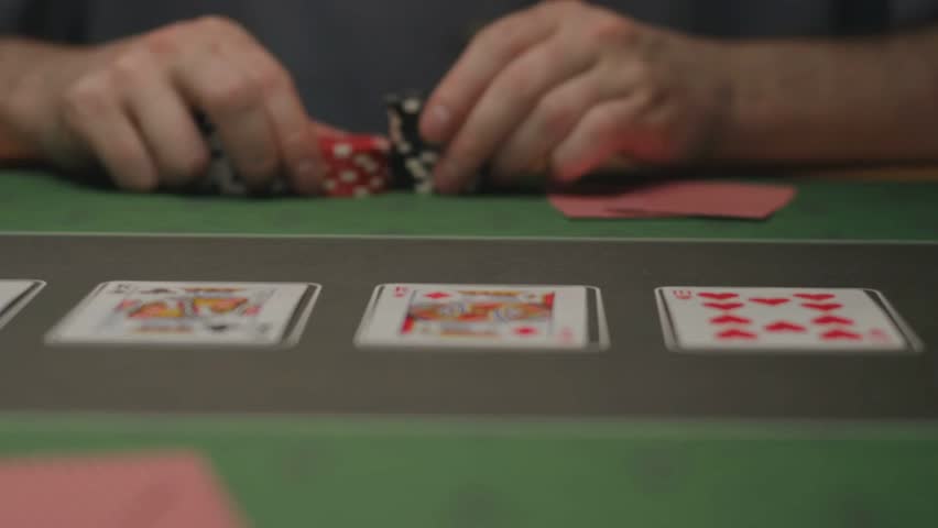 Detailed view of poker chips and playing cards arranged on a casino table, suitable for gambling, betting, and card game content.
