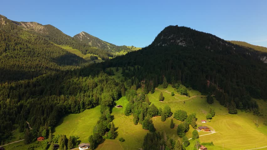 Wooden mountain cabins on green slopes in Heutal, Austrian Alps. Summer nature landscape, Salzburg.