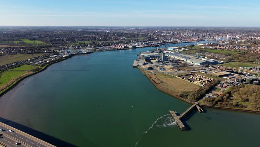 Panning aerial view of Ipswich harbour and Orwell Estuary showing wastewater treatment outfall discharging water