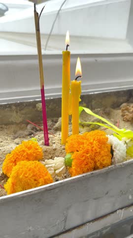 Candles, Incense Sticks and Thai Flower Garland in Joss Stick Pot in front of Chapel at the Temple, For Walk Around the Temple with a Candle at Bangkok, Thailand. 29 JUL 2026, A.M. Slow Down Video