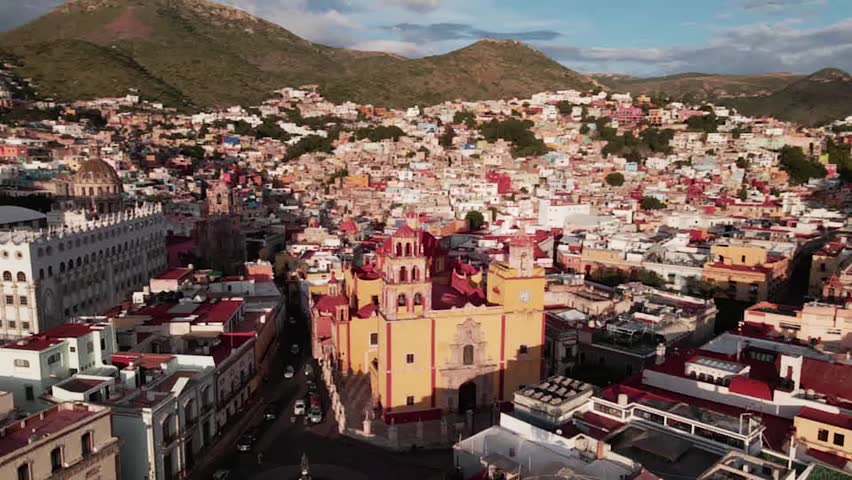 Panoramic aerial view of Guanajuato city center with the university and basilica surrounded by colorful hills in Mexico