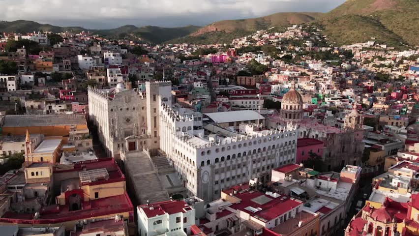 Panoramic aerial view of Guanajuato city center with the university and basilica surrounded by colorful hills in Mexico