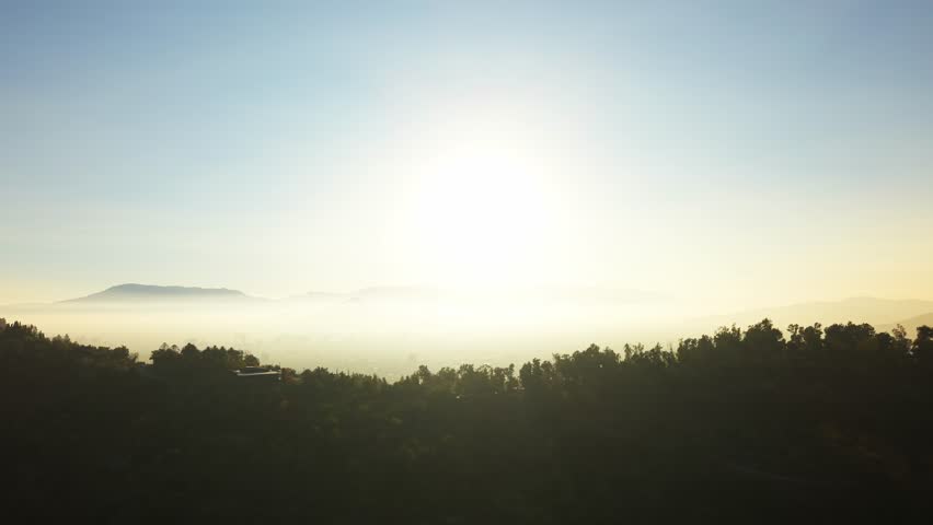 Drone Horizontal Zooming Out View of Sun Rising Over a Polluted Hazy Valley and Hills, Sunrise, Chile