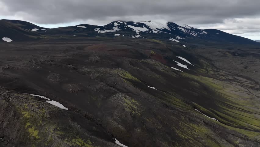 aerial View of Icelandic Volcanic Highland Landscape with Snow Capped Mountains and Dark Lava Fields