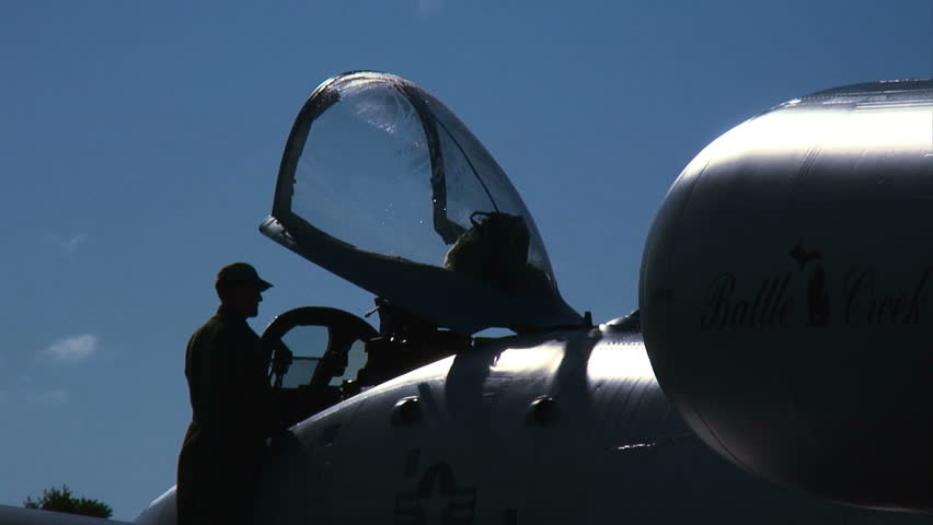 Member of the air force at the cockpit of an A-10 Thunderbolt, silhouetted
