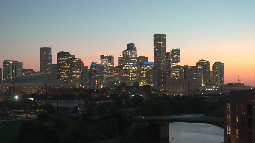 Downtown Houston skyline illuminated at blue hour overlooking Buffalo Bayou, featuring modern skyscrapers and the city skyline at dusk in Houston, Texas, USA.