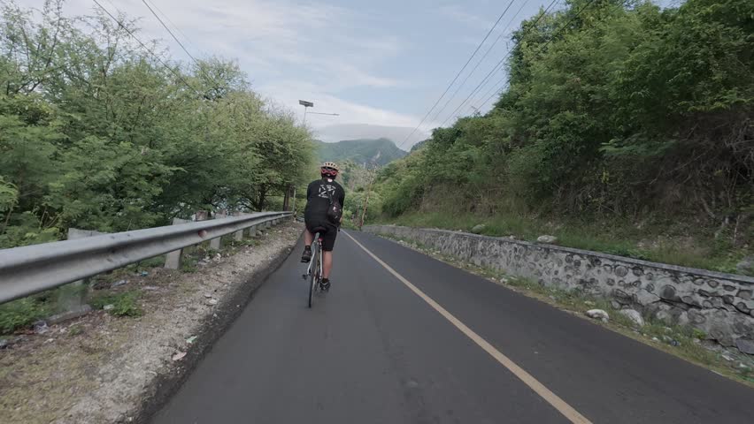 Cyclist Riding on Scenic Mountain Road