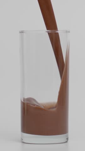 Super Slow Motion of Filling Transparent Glass with Chocolate Milk, Vertical Video