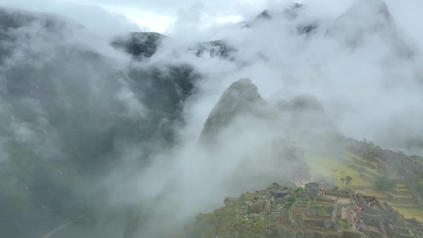 Clouds and fog moving over Machu Picchu ruins in Peru