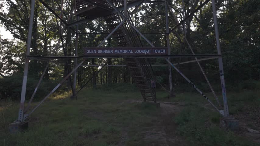 Low Angle Shot Looking Up Steel Fire Lookout Tower Against Dusk Sky A dramatic low-angle shot looking directly up the geometric steel lattice framework of a vintage fire lookout tower.