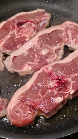 Close-up of prime lamb loin chops cooking.