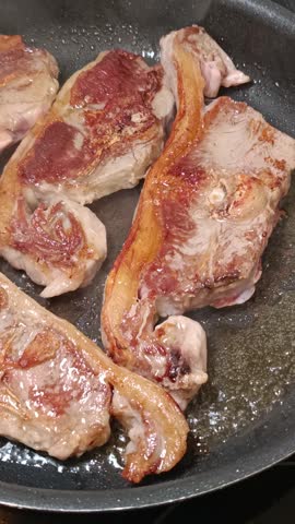 Close-up of prime lamb loin chops cooking.