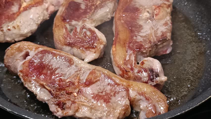 Close-up of prime lamb loin chops cooking.