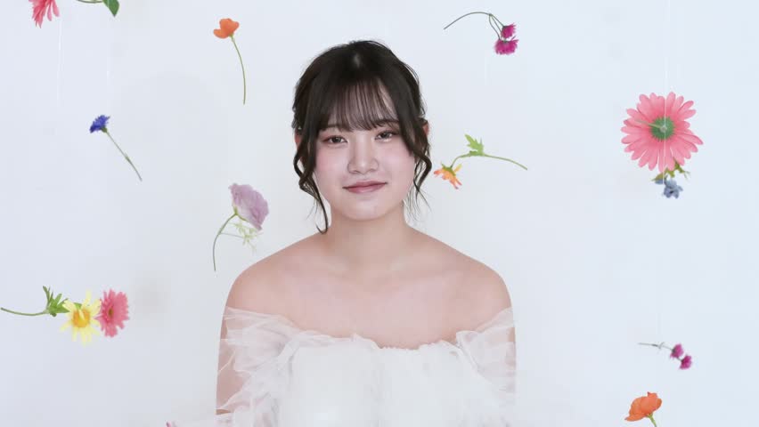 Teenage Woman Wearing a Wedding Dress Surrounded by Flowers