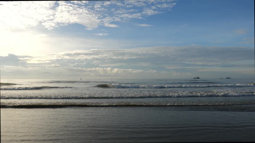 Dramatic Blue Sky with Clouds Over Wide Ocean Horizon and Beach	