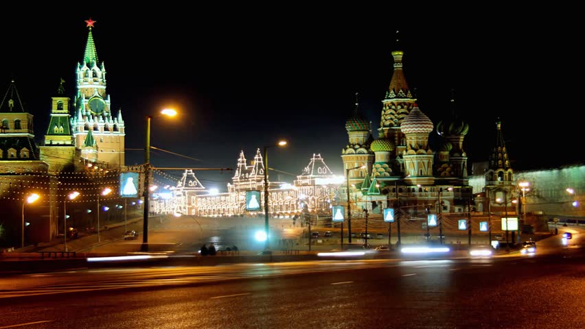 Night time lapse video of Red Square in Moscow, showing St Basil’s Cathedral, Moscow Kremlin, city lights, roads, and moving traffic. A striking urban scene combining historic landmarks with nighttime city activity.