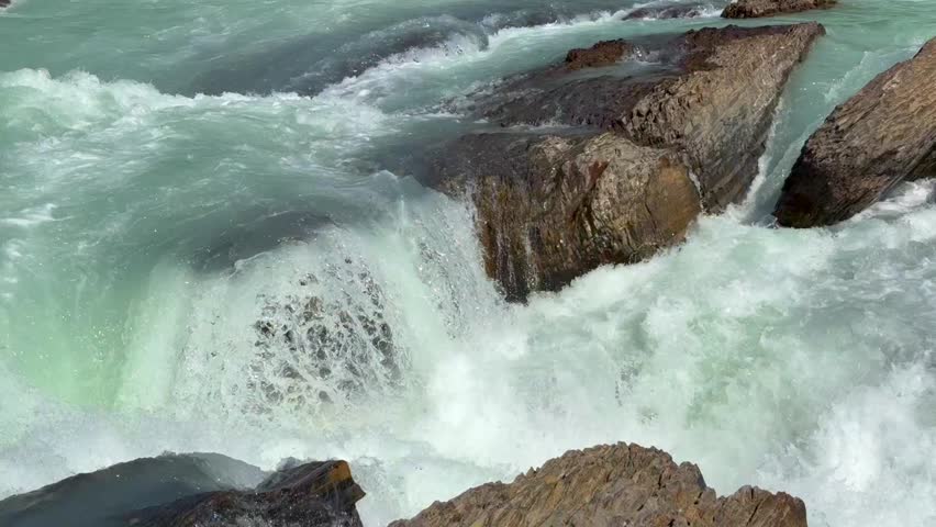 Beautiful view on the powerful Kicking Horse River in Yoho National Park. Canada. British Columbia,. Water flows rapidly over rocks in a river, creating white foam and splashes in a natural outdoor setting