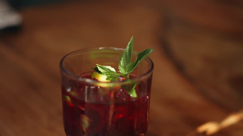 Close up of a glass of chicha morada, a traditional peruvian purple corn drink, on a wooden table