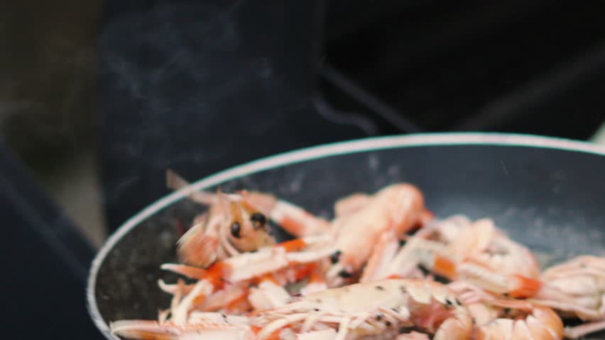 Fresh Langoustines Flipped in Hot Pan in Slow Motion. Shellfish Seafood being Cooked Outdoors. Norway Lobster.