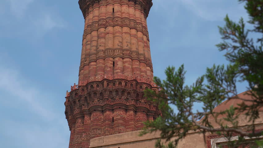 Static close up shot of the balcony details, intricate carvings, and red sandstone texture of Qutub Minar tower in New Delhi, India.