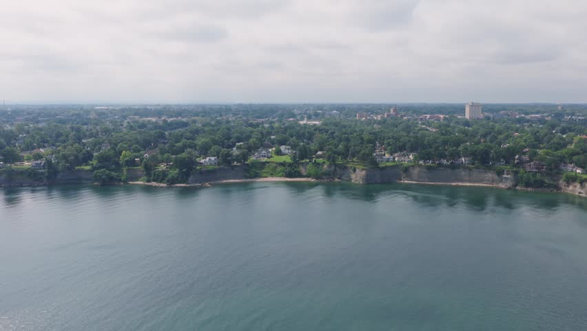 Cleveland, OH drone aerial of homes, houses, apartments, public parks, and beaches along coast line coastline of Lake Erie of great lakes in North American Ohio landscape during summer overcast day 4k