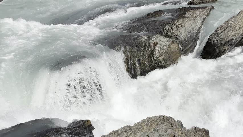 Beautiful view on the powerful Kicking Horse River in Yoho National Park. Canada. British Columbia,. Water flows rapidly over rocks in a river, creating white foam and splashes in a natural outdoor setting