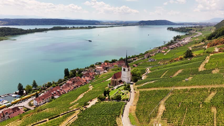 Ligerz, Lake Biel, Bern, Switzerland, revealing St. Peter Church, terraced vineyards, the lakeside village and the Swiss wine region, drone pullback.