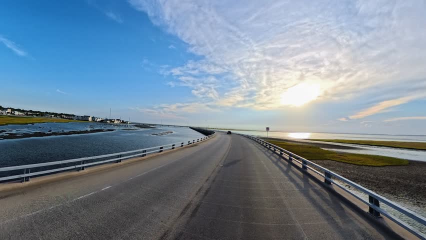 Forward Driving View Across Chincoteague Bridge Surrounded by Tidal Water and Marshland.

