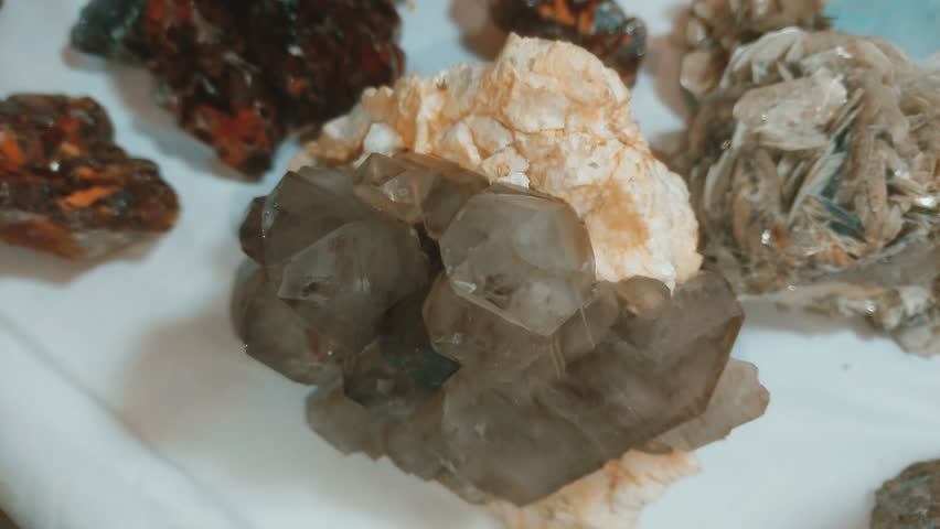 Explore a captivating assortment of raw mineral specimens featuring remarkable black tourmaline and deep smoky quartz crystals in their natural forms. This diverse geological collection highlights stunning unpolished gems including vibrant spodumene and rich reddish brown crystal clusters perfect for avid rock collectors. Each authentic earth stone showcases unique natural formations and striking prismatic structures that celebrate the incredible beauty of organic geology. Enhance your premium mineral display or lapidary crafting projects with these extraordinary raw crystalline treasures extracted directly from the earth.