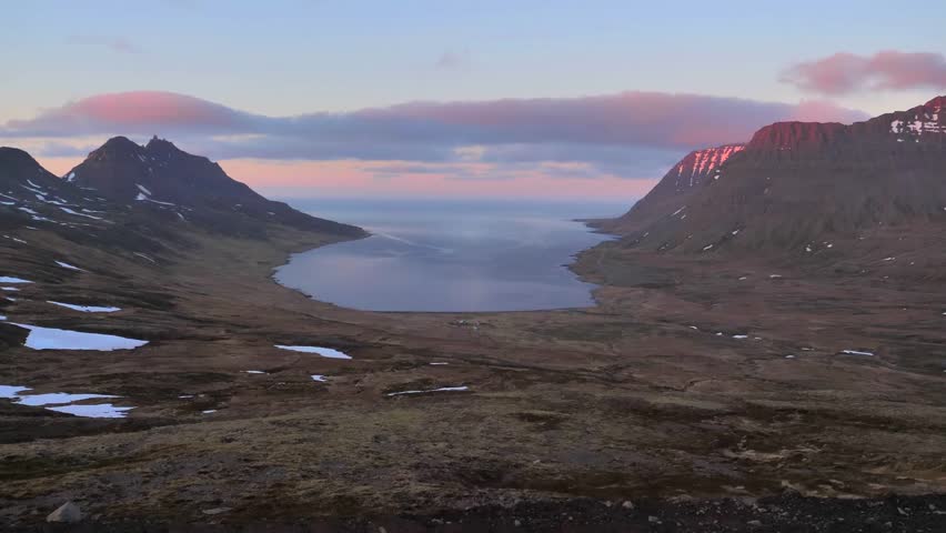 Sunset view of Eyjafjordur Fjord near Akureyri in North Iceland featuring calm water mountain peaks colorful evening sky and rugged valley landscape