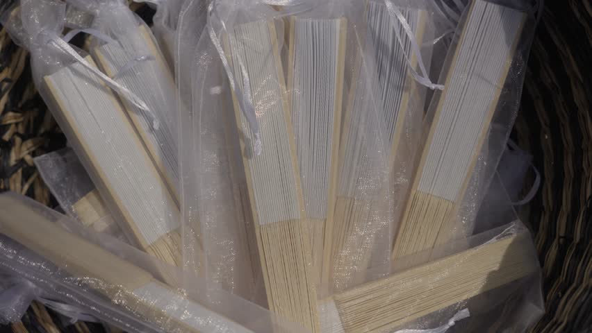 Close-up View of Folding Hand Fans in Organza Pouches as Wedding Favors