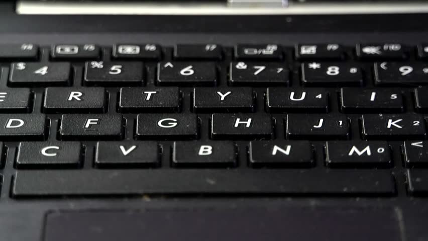 Close-up of white numbers and letters on the keys of a black laptop keyboard