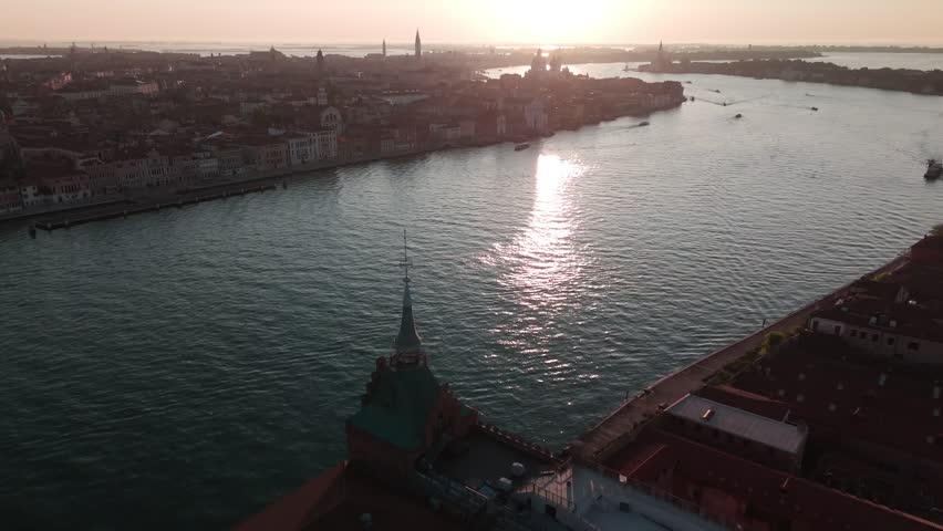 Aerial view of church tower overlooking lagoon at sunset