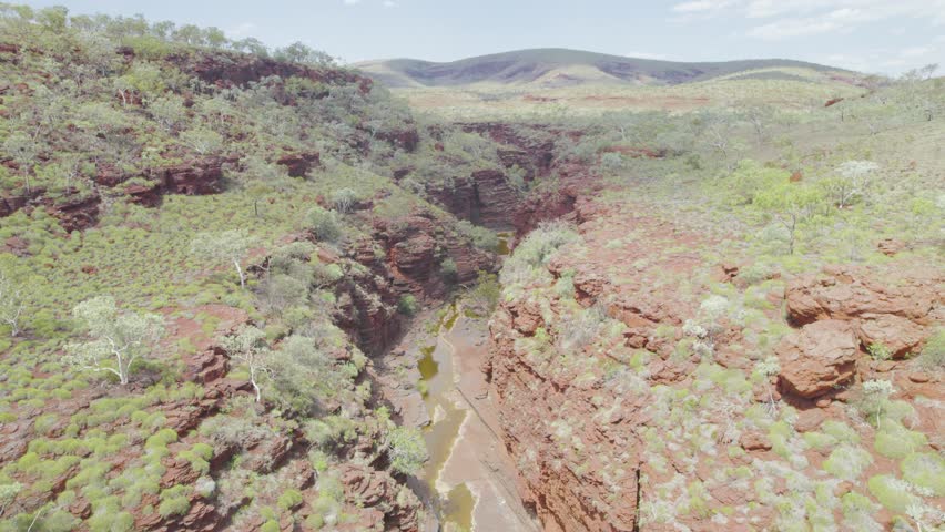 Aerial Helicopter Flight Over A Deep Red Rock Gorge In Western Australia Revealing A Rugged Outback Wilderness Landscape.