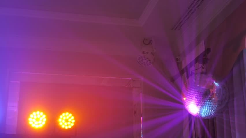 Disco ball and LED spotlights with multi-colored beams.