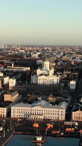 Warm sunlight illuminating the iconic helsinki cathedral and government palace in senate square, with an expansive aerial perspective capturing the city