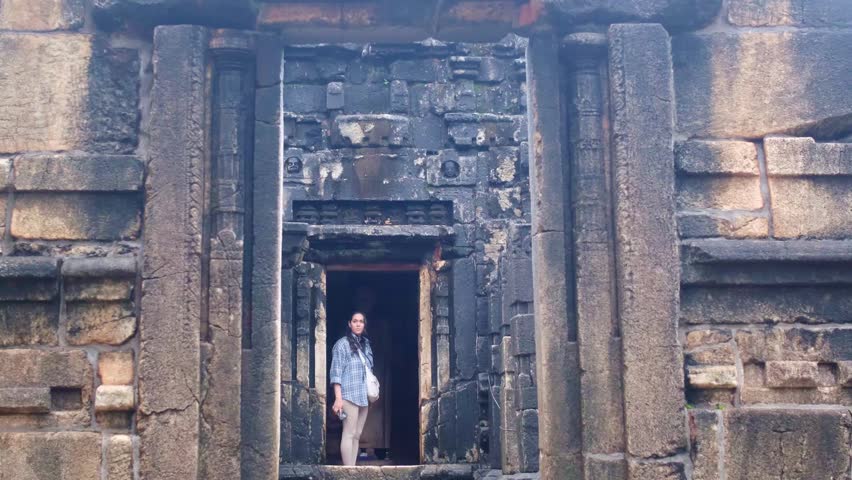 Woman tourist standing in ancient stone doorway at Nalanda Gedige temple in Sri Lanka