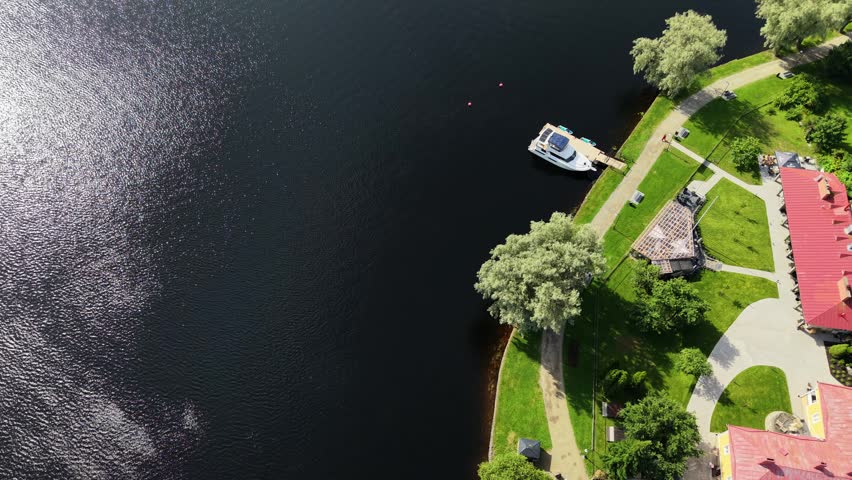 Aerial panoramic view of medieval Olavinlinna Castle surrounded by Lake Saimaa under a blue sky in Savonlinna, Finland.