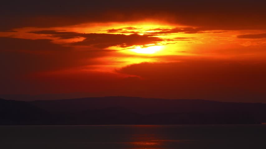 Breathtaking sunset view with intense red and orange glow over the tranquil Adriatic sea at Senj, Croatia