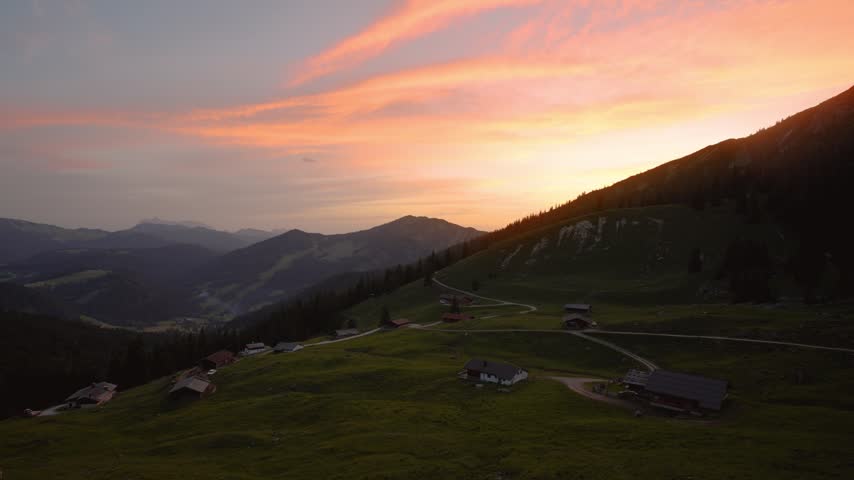 Golden sunset over rolling alpine pastures with traditional alm huts and mountain panorama, Unken, Austria