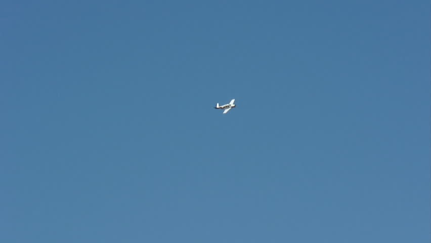 Beechcraft Bonanza, small plane flying in a deep blue sky.