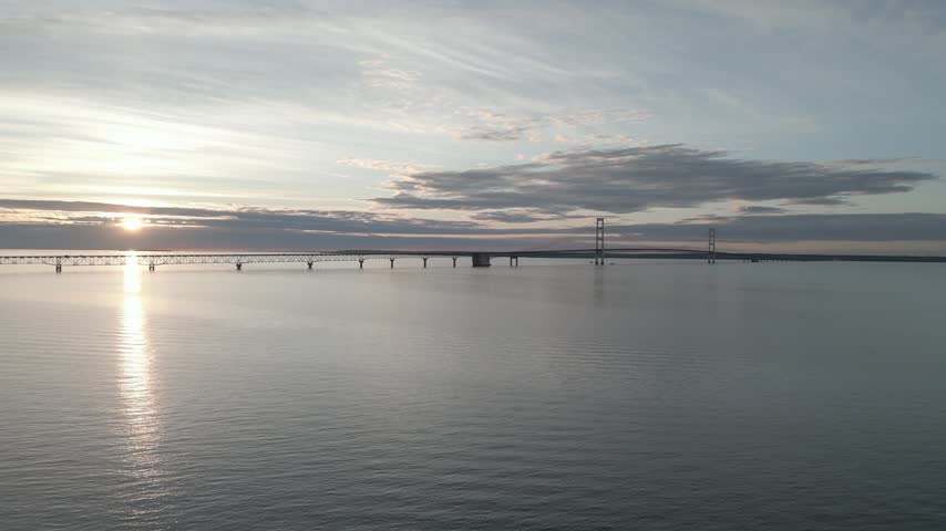 Slow steady wide shot of Mackinac Bridge near sunset.