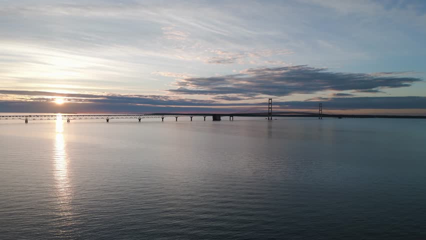 Slow steady wide shot of Mackinac Bridge near sunset.