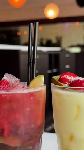 wo glasses of mango and strawberry smoothies are placed on a wooden cutting board. mango and strawberry smoothies, healthy juice, healthy drinks, healthy drink menu