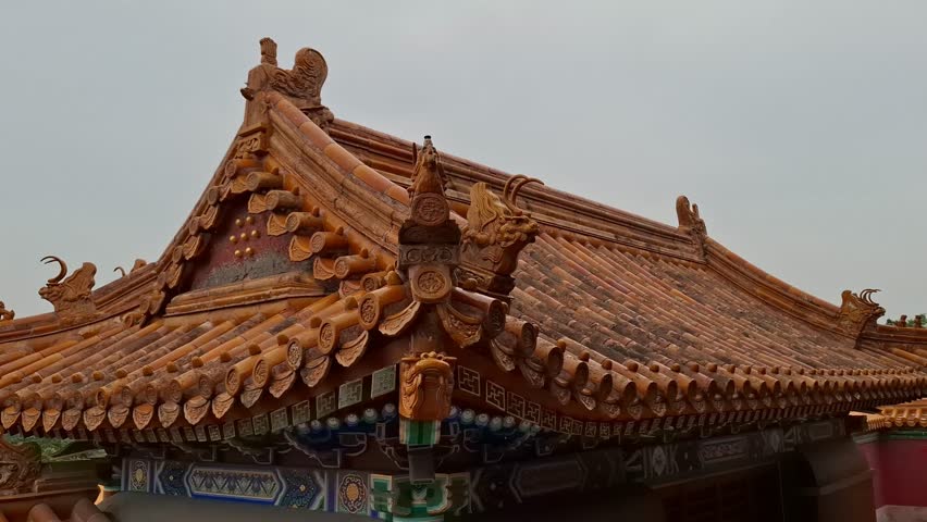Traditional Chinese pavilion roof fragment with yellow glazed tiles stands under a cloudy sky outdoors. Asian tourism, historical landmarks, summer palace Beijing.