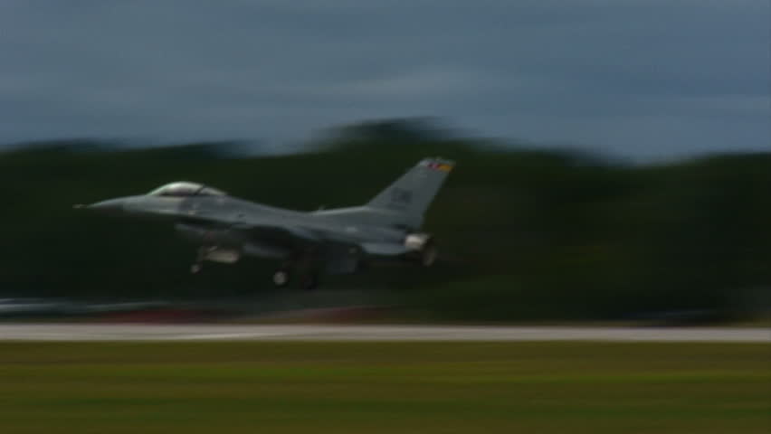 USAF fighter plane landing on runway.